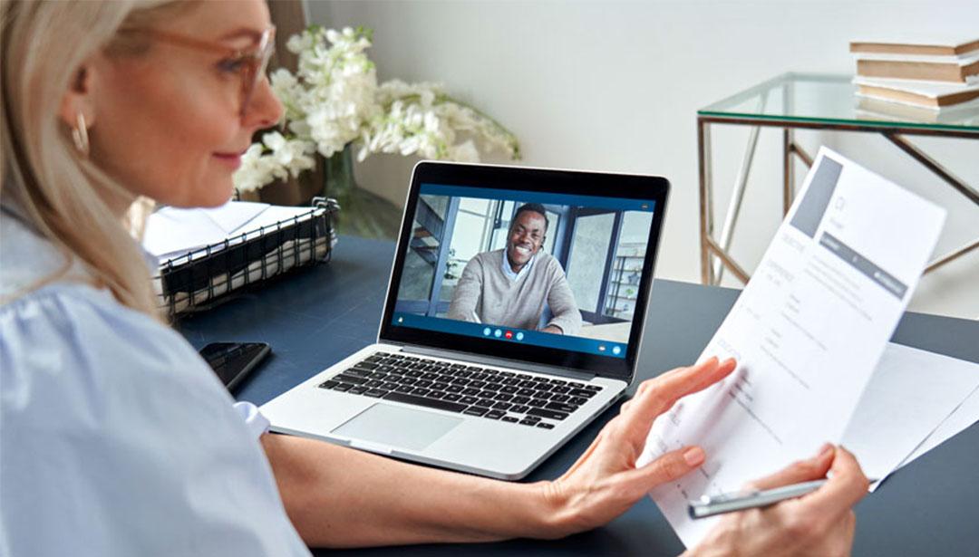 Woman looking at a document while on a video call